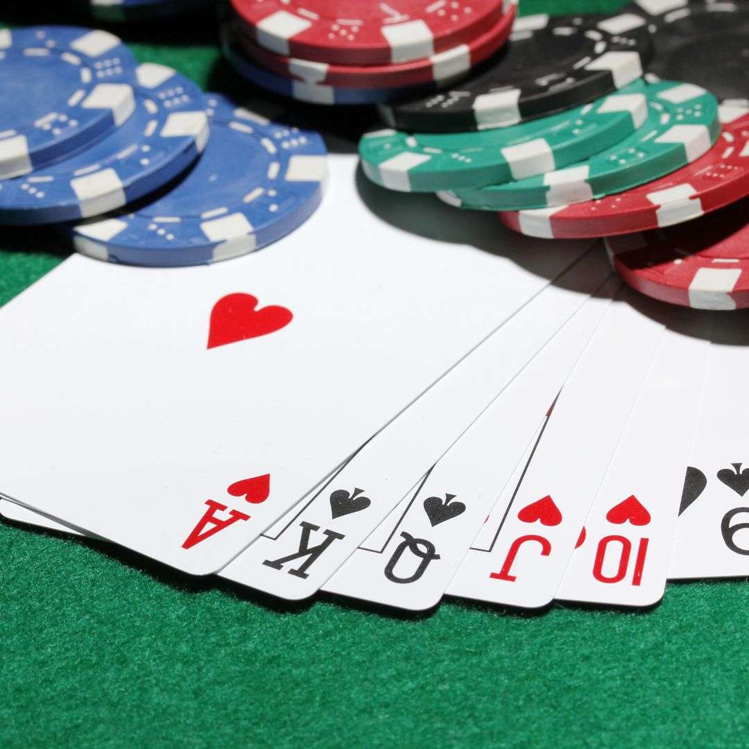 Poker chips, and playing cards arranged on a poker table.