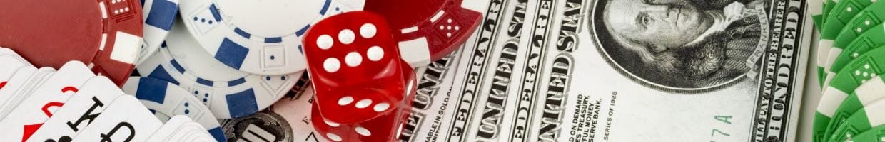Playing cards, poker chips, red six-sided dice, and money all layered together.