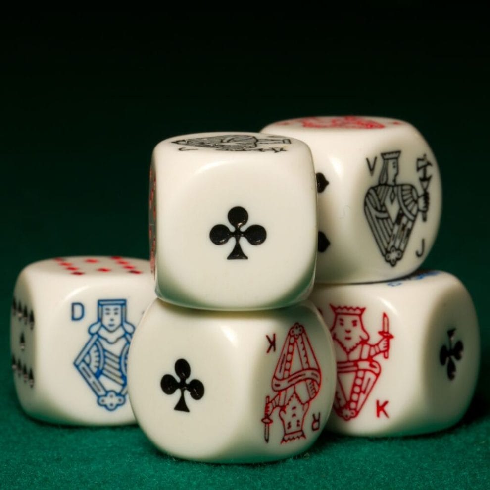 Poker dice against a black background.