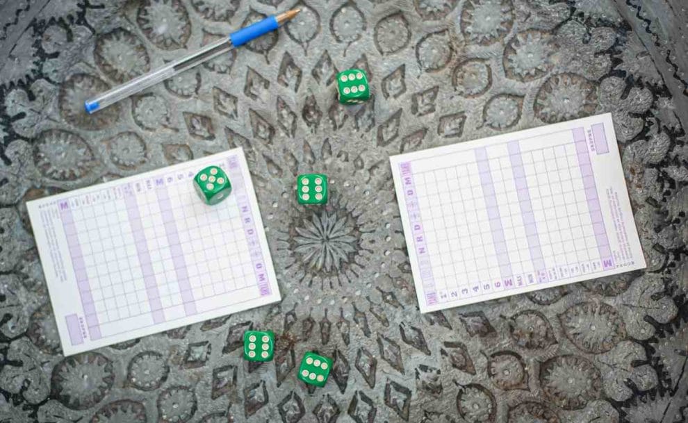 Yahtzee game with scorecard and dice with a pen.