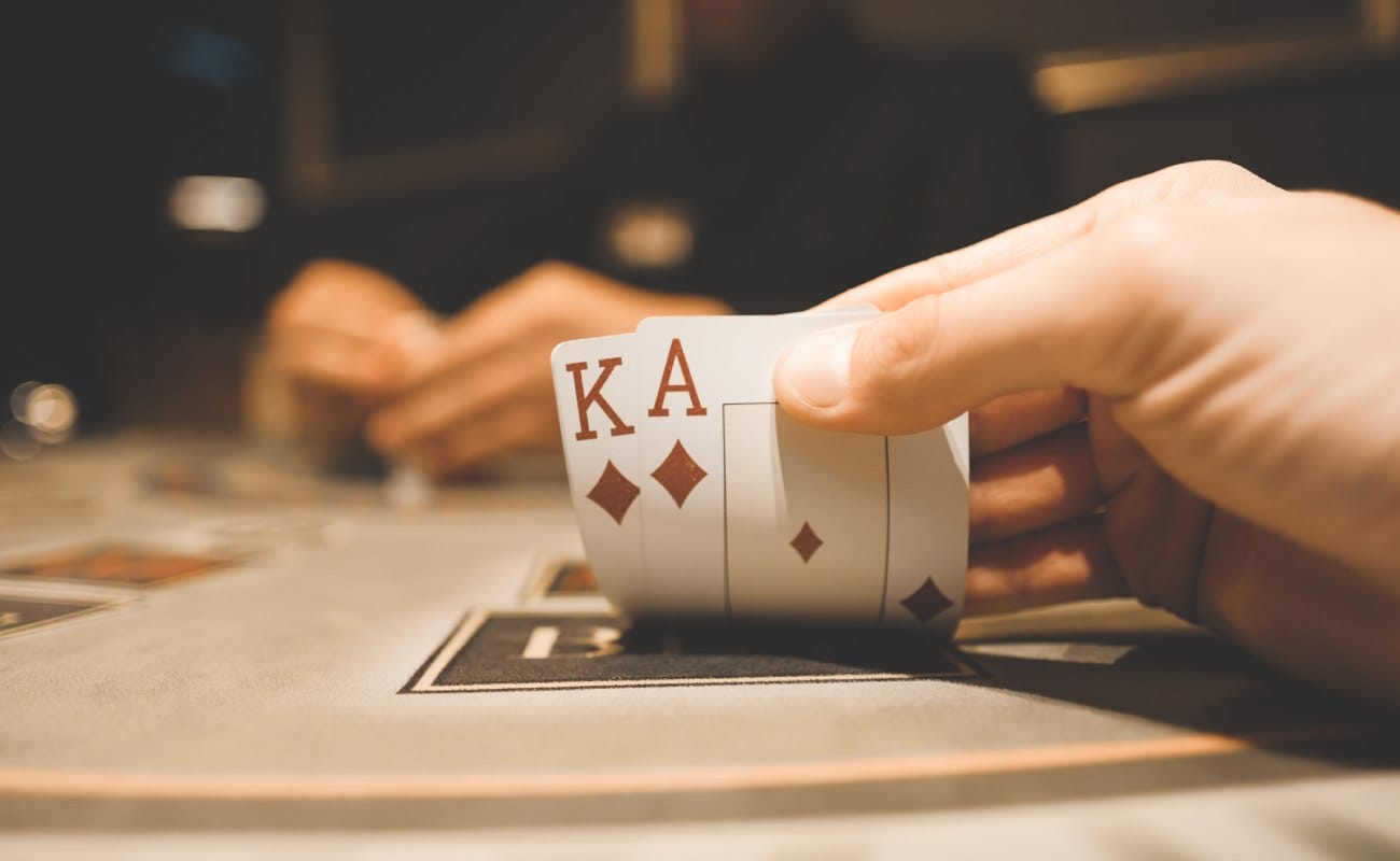 A hand holding blackjack playing cards.