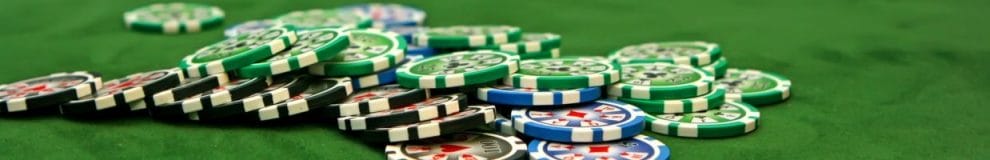 Poker chips scattered on a green felt poker table 