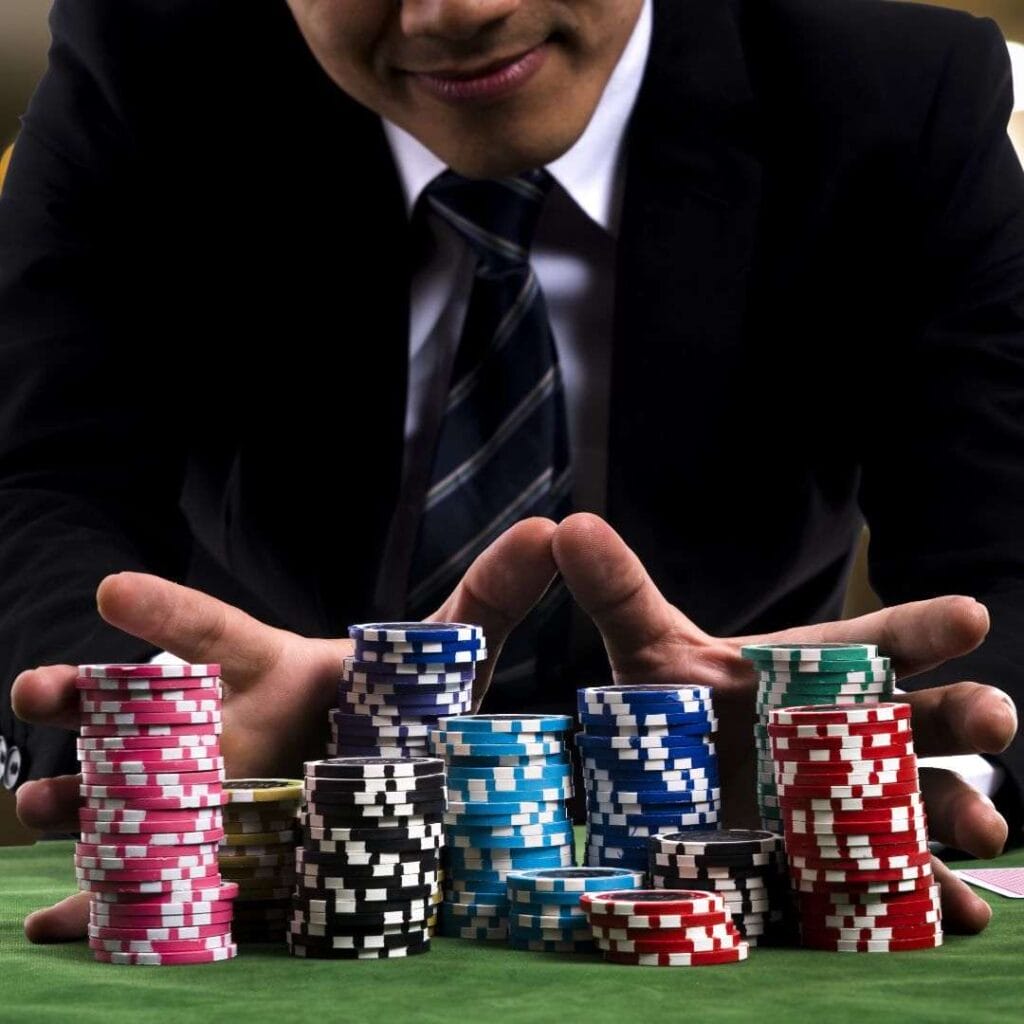 a man pushes stacks of poker chips forward on a poker table