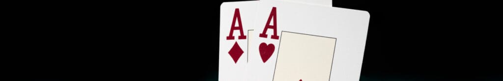 Blackjack Ace cards and casino chips against a black background.