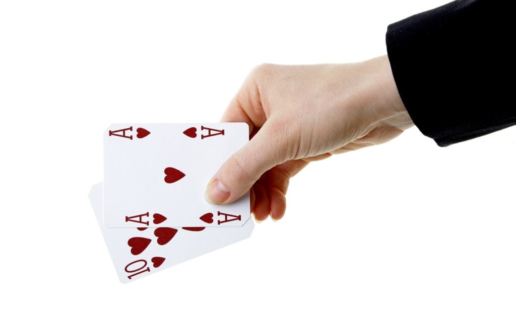 A hand holding two playing cards.