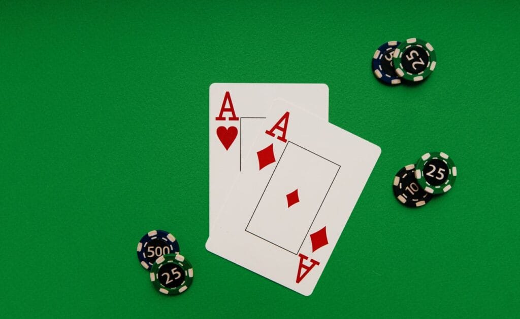 Ace playing cards and casino chips on a green table.