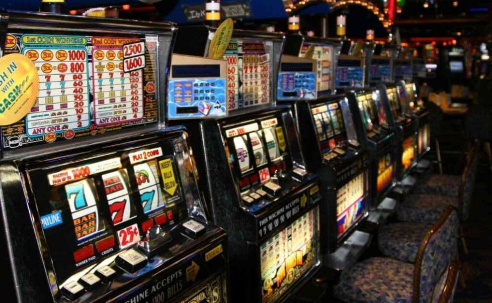 Old-school slot machines lined up on a casino floor. 