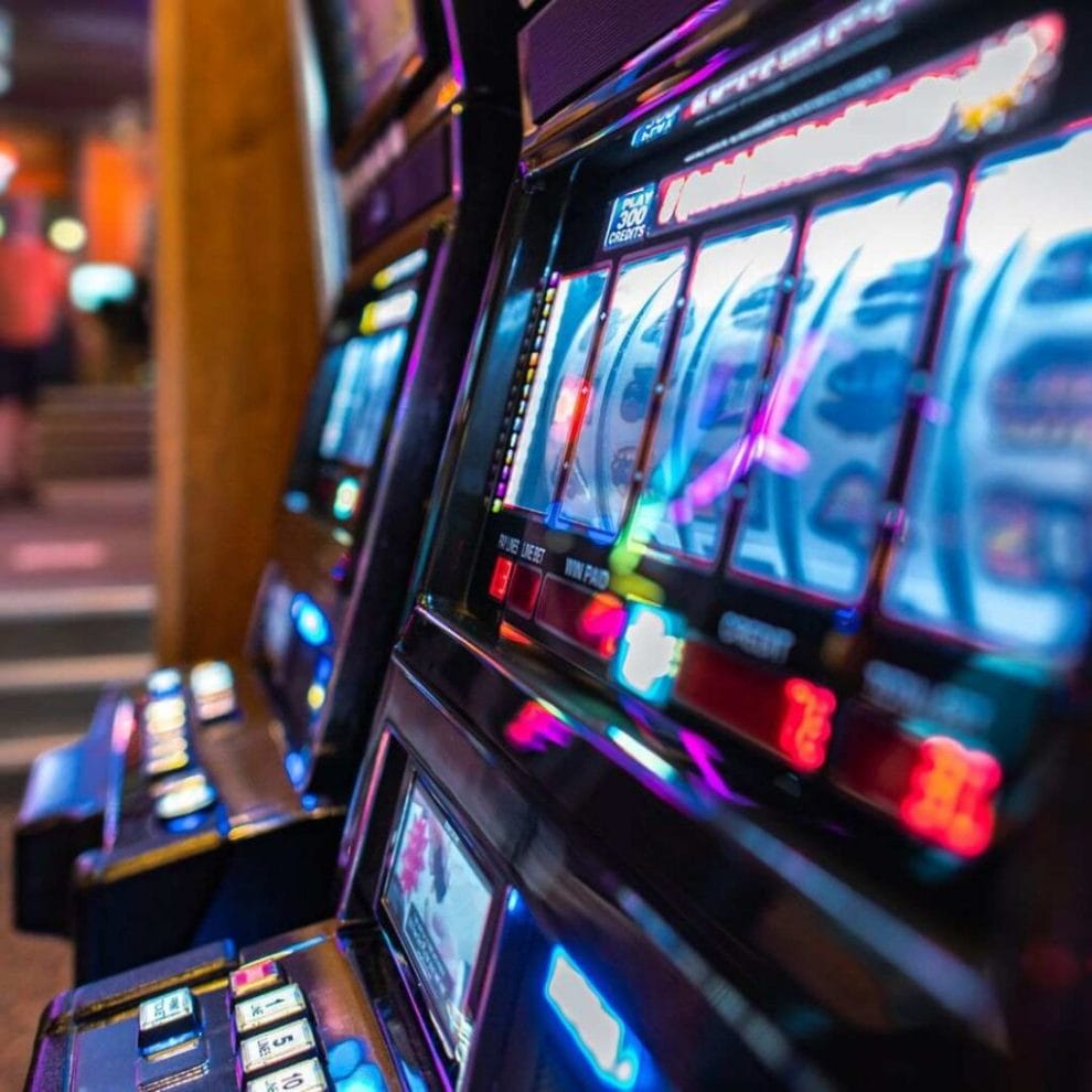 A side-view closeup of a lit-up slot machine at a casino.