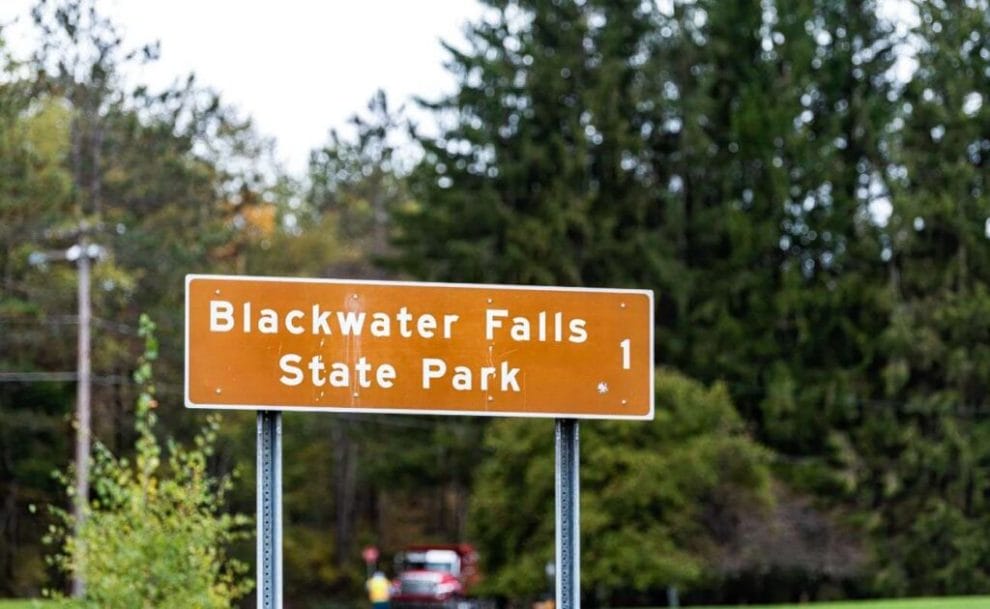an informative road sign that has “Blackwater Falls State Park” on it
