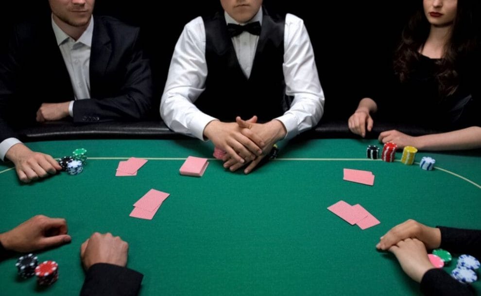 A group of people sitting at a poker table.