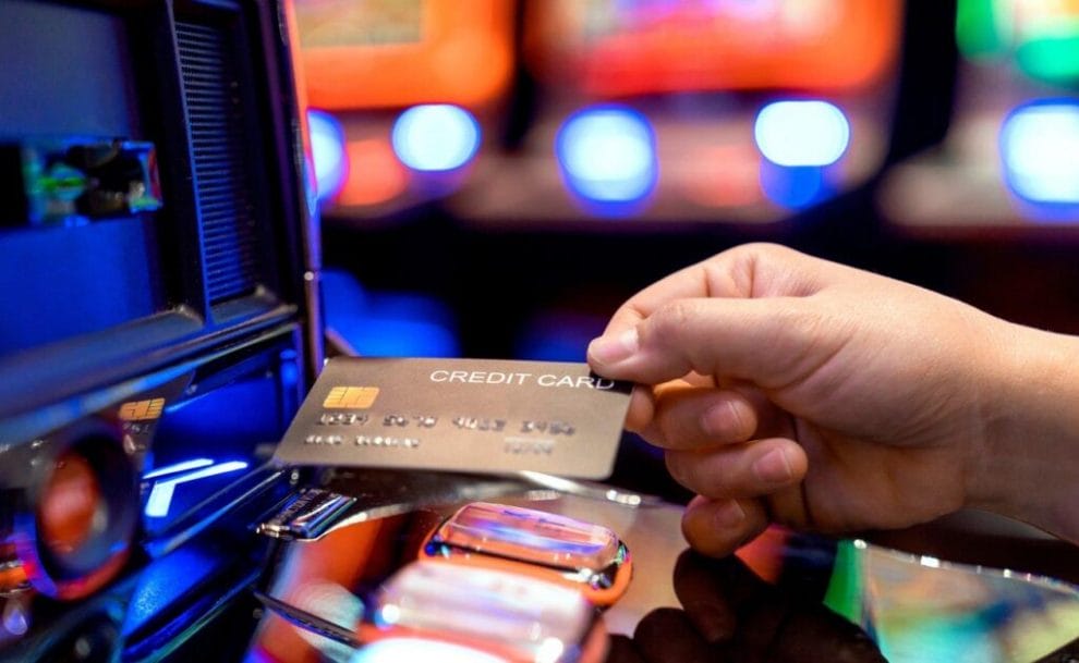 A person using a credit card to buy slot credits.