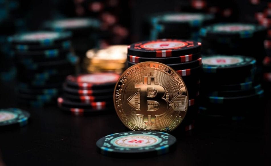 Bitcoin and casino chips on a poker table.