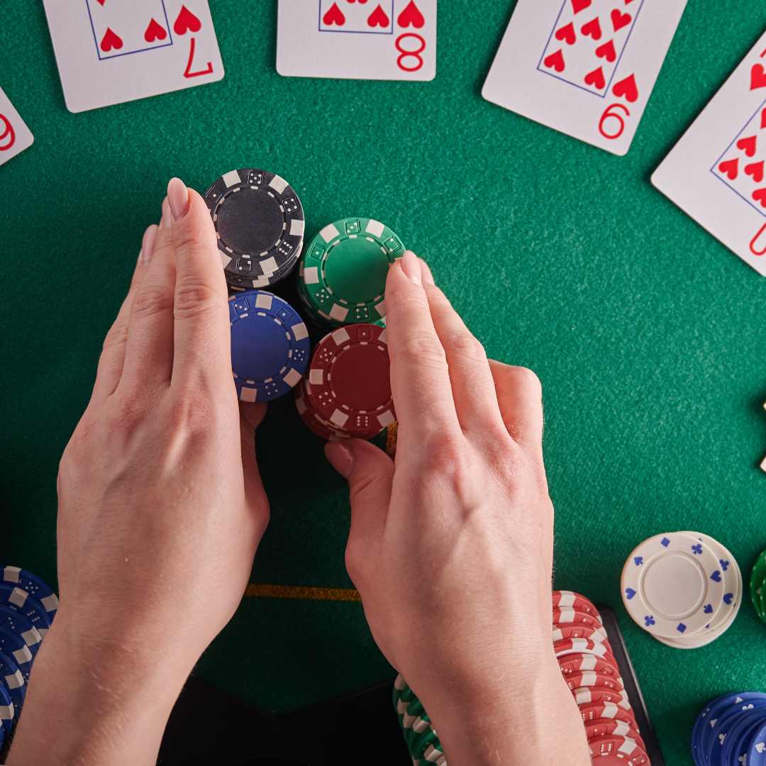 A poker player pushes casino chips on a poker table.