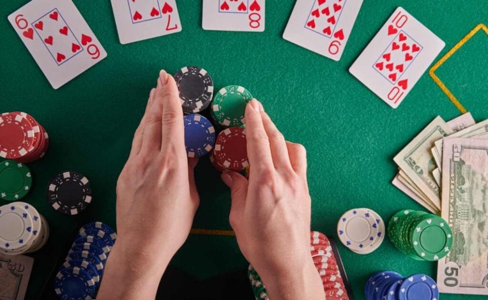 A poker player pushes casino chips on a poker table.