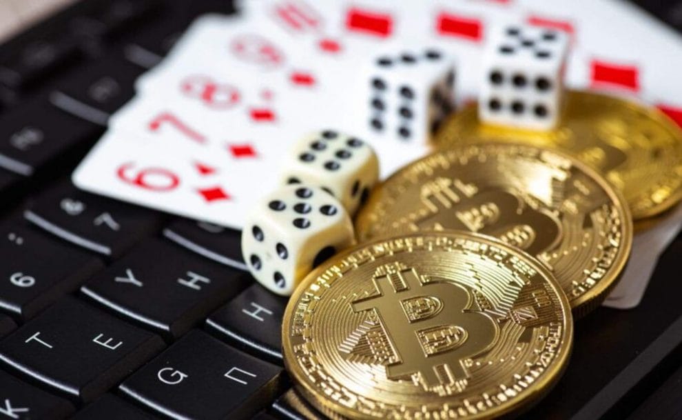 Playing cards, dice, and bitcoins on a computer keyboard.