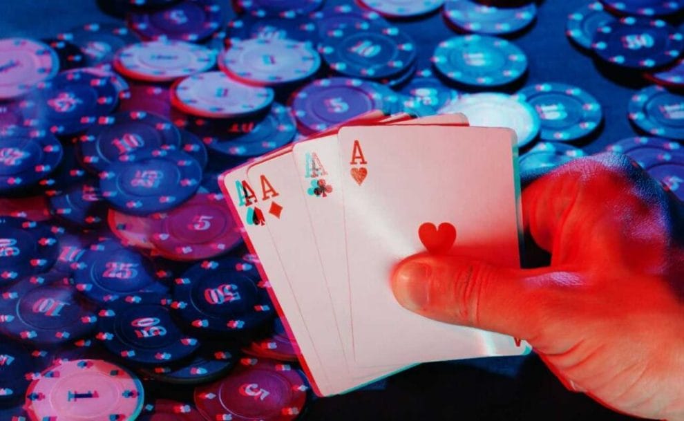 a virtual reality online poker concept of a person holding four of a kind ace playing cards above a table that has poker chips scattered all over it with a technological glitch effect over the image 