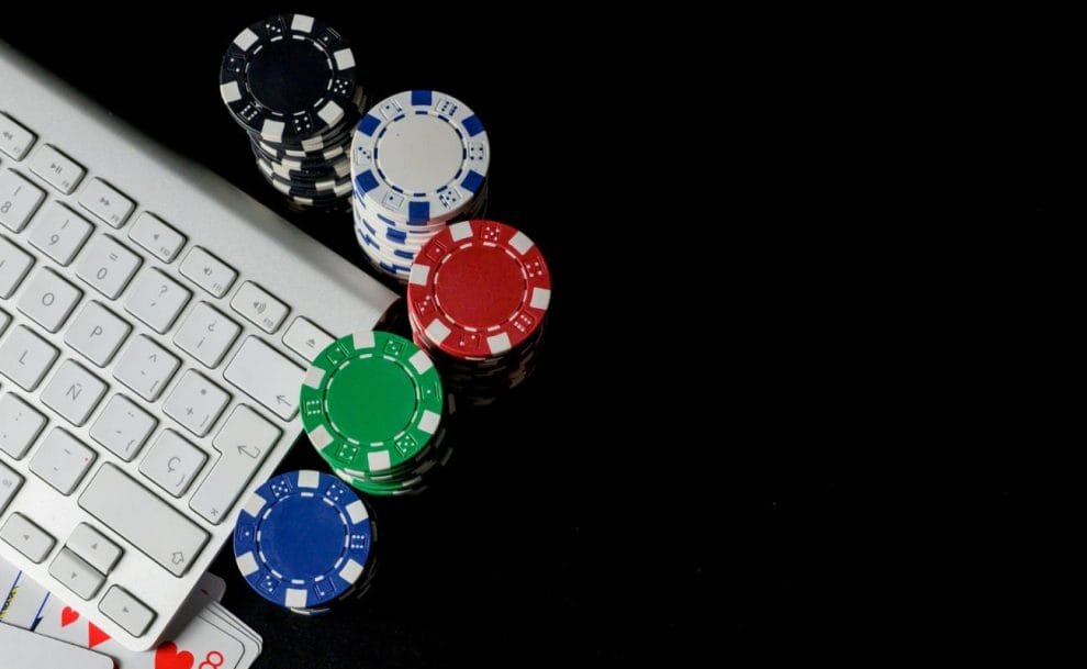 Casino chips and playing cards arranged around a computer keyboard. 