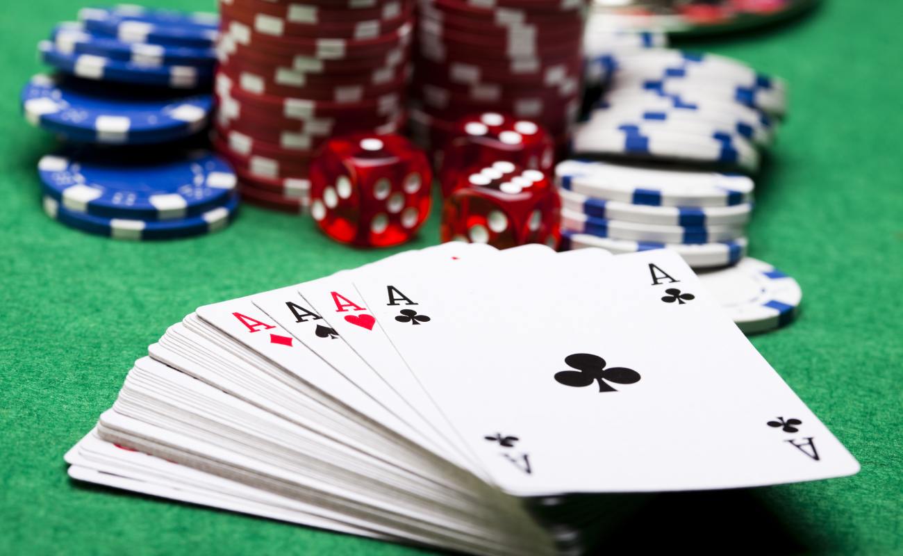 Playing cards, dice and casino chips on a green felt table.