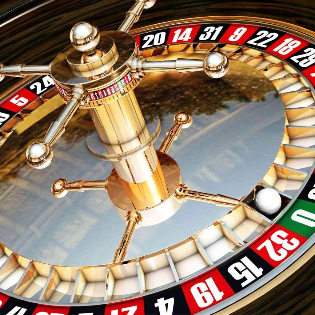 A roulette wheel with the white ball resting in the green 0 slot.