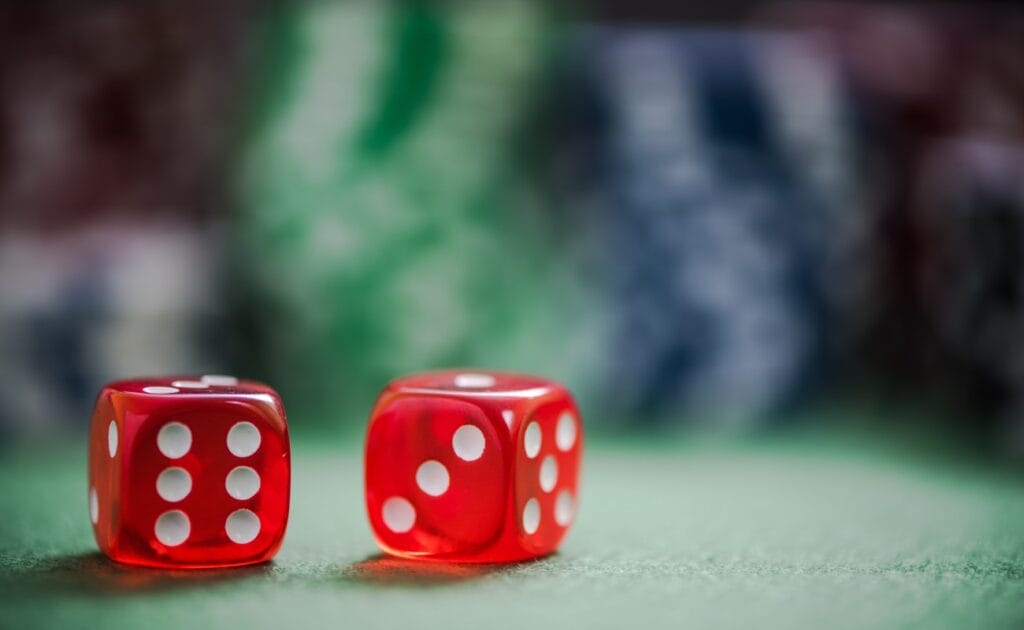 Red dice on a green table.