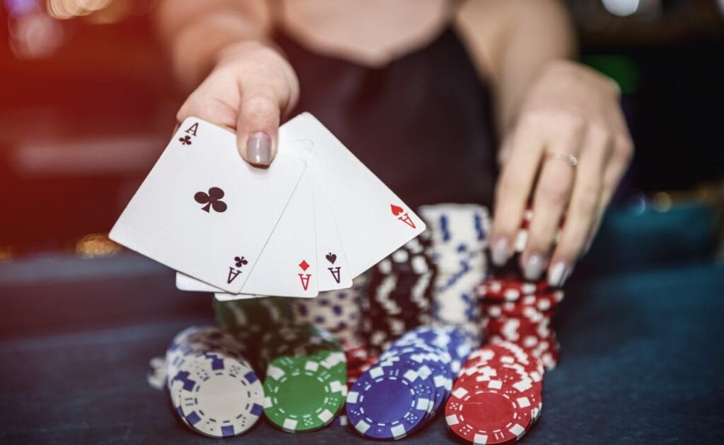 A poker player showing her playing cards with poker chips on the table.