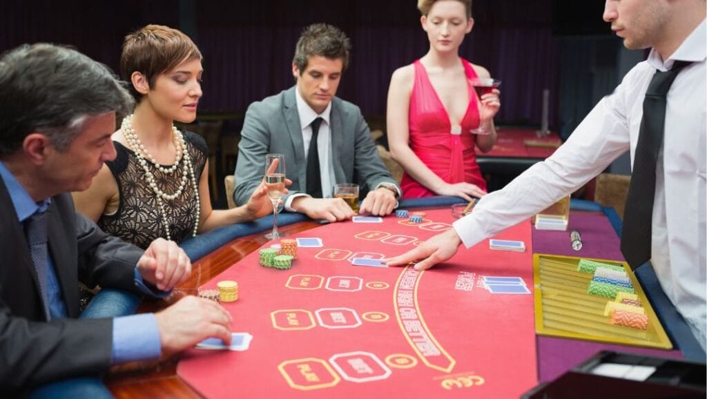 A group of people, and a poker dealer, sitting around a poker table, playing a game of poker.