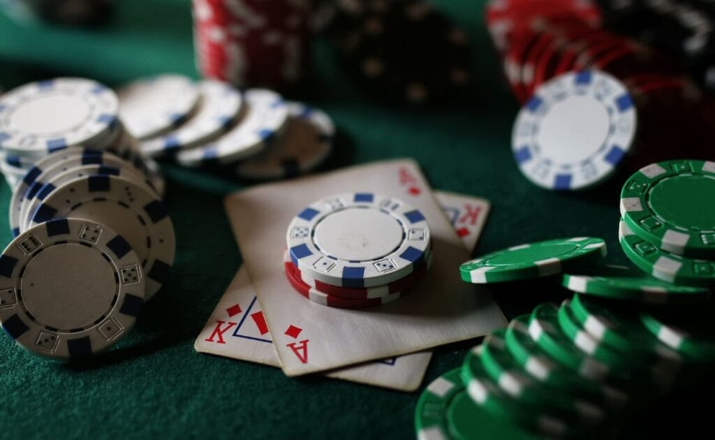 Casino chips, and playing cards, arranged on a green poker table.