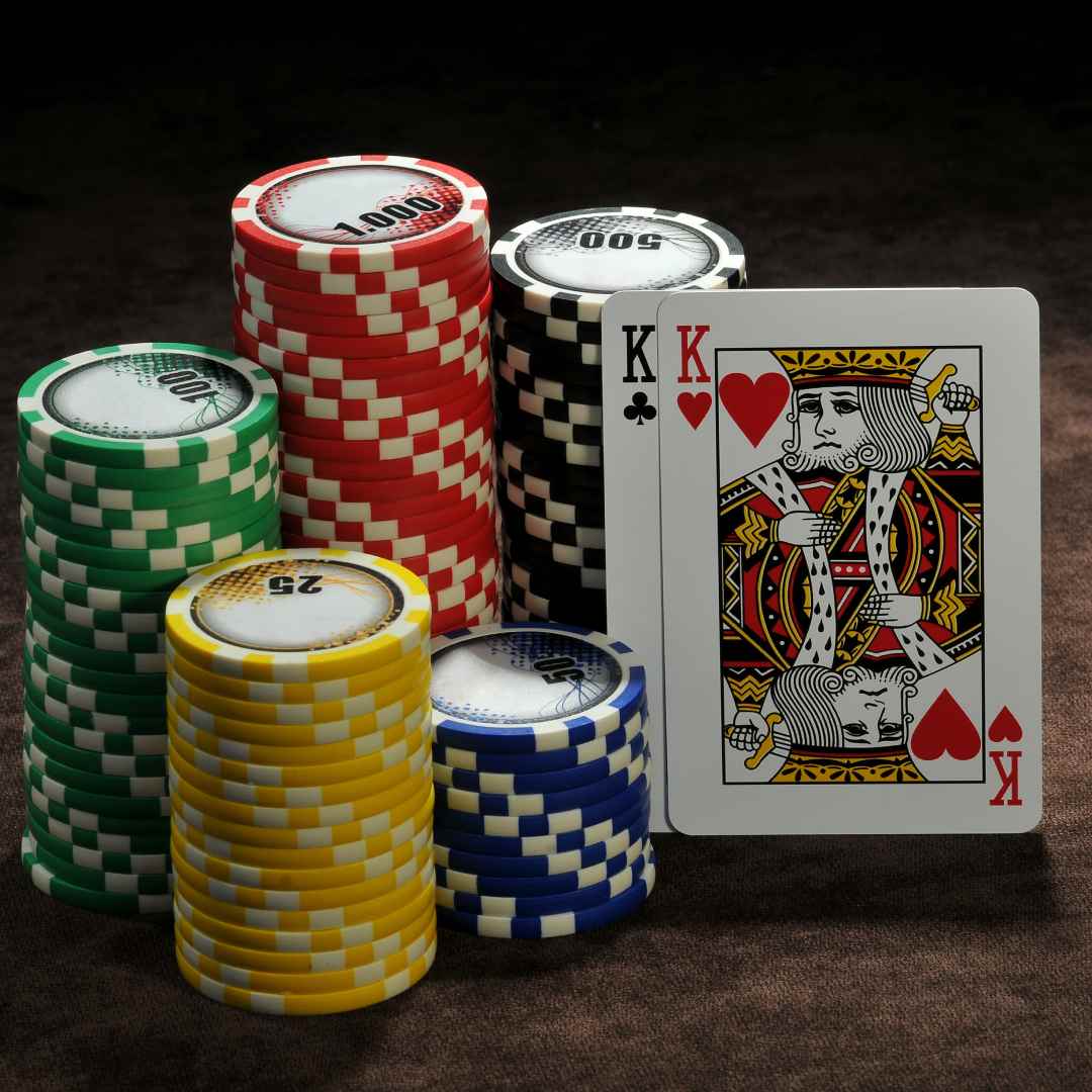 Playing cards and casino chips on a brown surface.