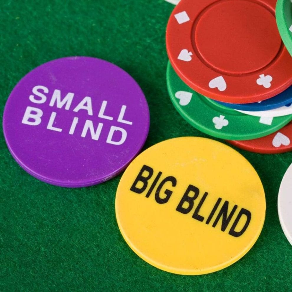 Special chips labeled 'Small Blind' and 'Big Blind' placed on the poker table alongside regular poker chips.