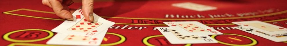 A croupier places cards down on a blackjack table