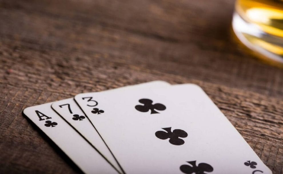 An ace, seven and three card on a wooden table