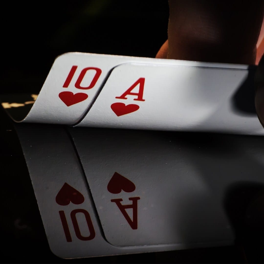 A pair of cards turned up to reveal an ace of hearts and a 10 of hearts.