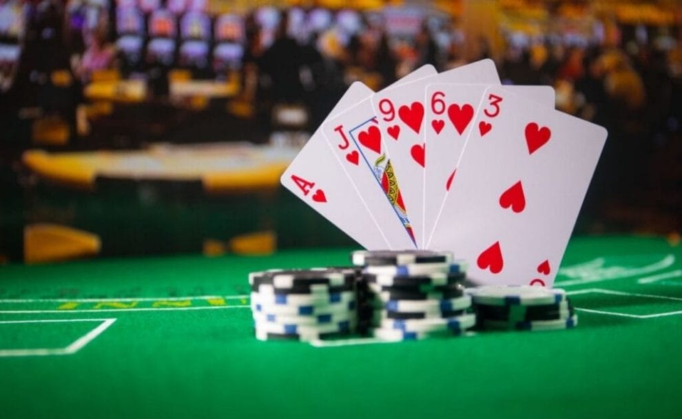 Poker chips, and playing cards, arranged on a poker table. 