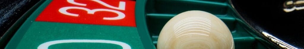 Closeup of a roulette ball in the “0” slot on the wheel.