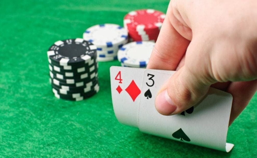 Casino chips and playing cards on a green felt table.