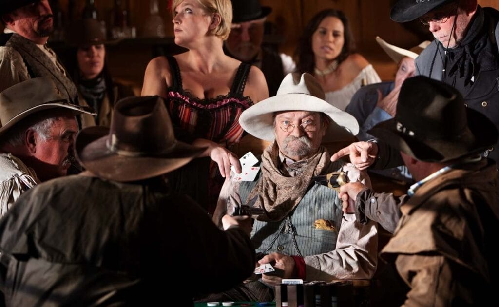 An old cowboy plays poker in a wild west saloon, surrounded by other people