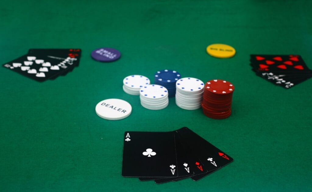  Black playing cards and casino chips on a green felt table.