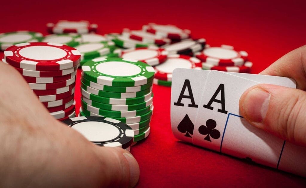 Two ace playing cards featured on a red casino table surrounded by casino chips.