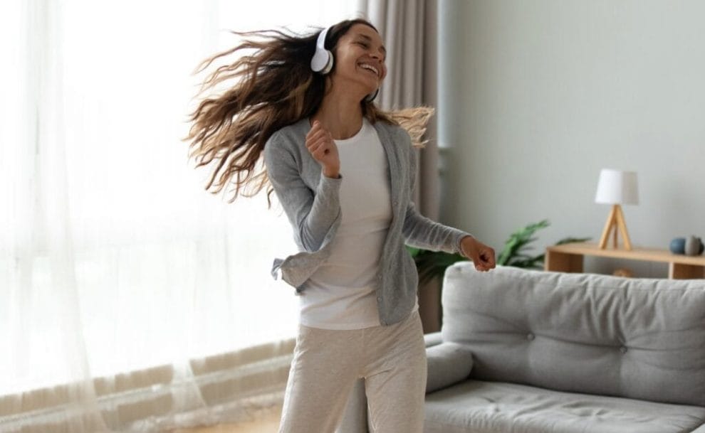 A person dancing in their living room while wearing headphones.
