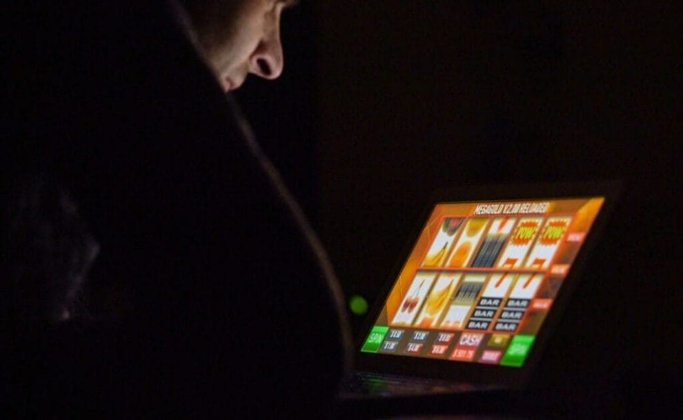 A man playing online slots on his laptop.