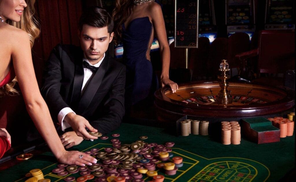 A glamorous casino with well-dressed people surrounding a casino table.