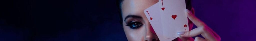 A person holding two playing cards up against their face.