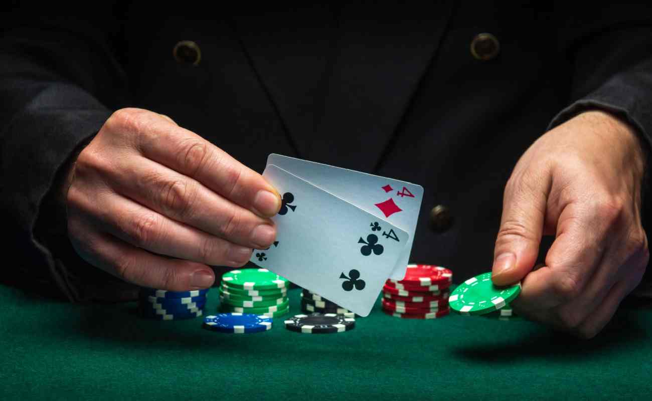 A player with a four pair putting a chip on a poker table