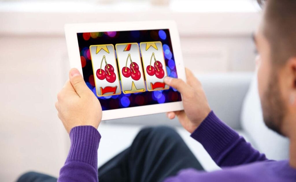 A man playing online slots on a tablet.