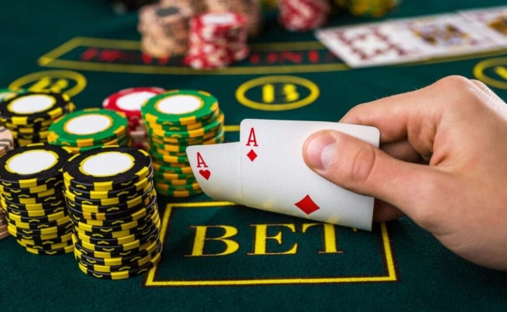 A poker player reveals an Ace pair at the poker table