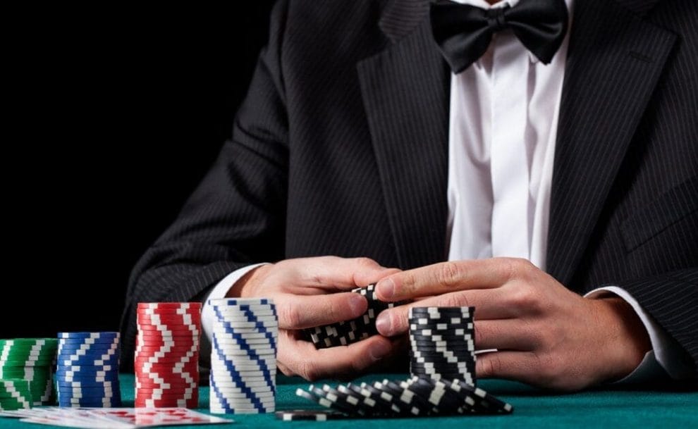 A poker player in a suit counting their chips.