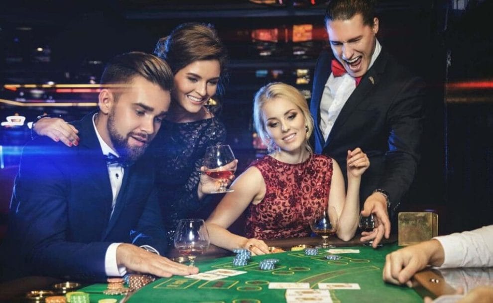 A group of friends sitting around a blackjack table at a casino.