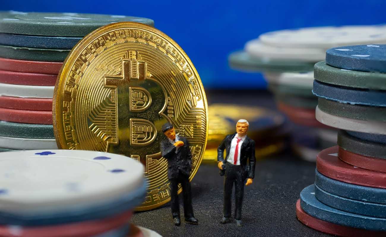 miniature businessmen with a bitcoin Coin and casino chips