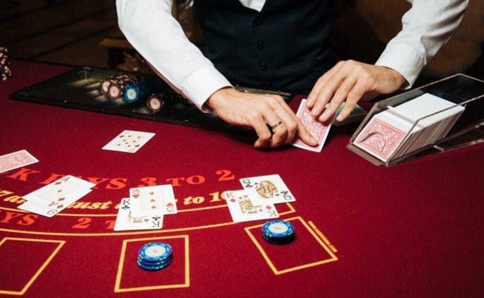 A dealer dealing cards in a game of blackjack from a cardholder.