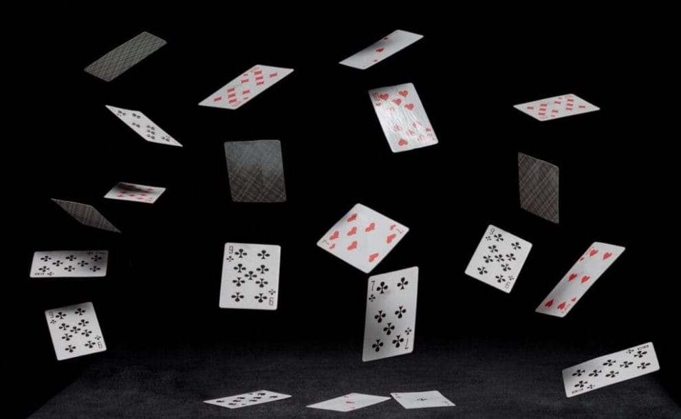 Playing cards fall on a black table